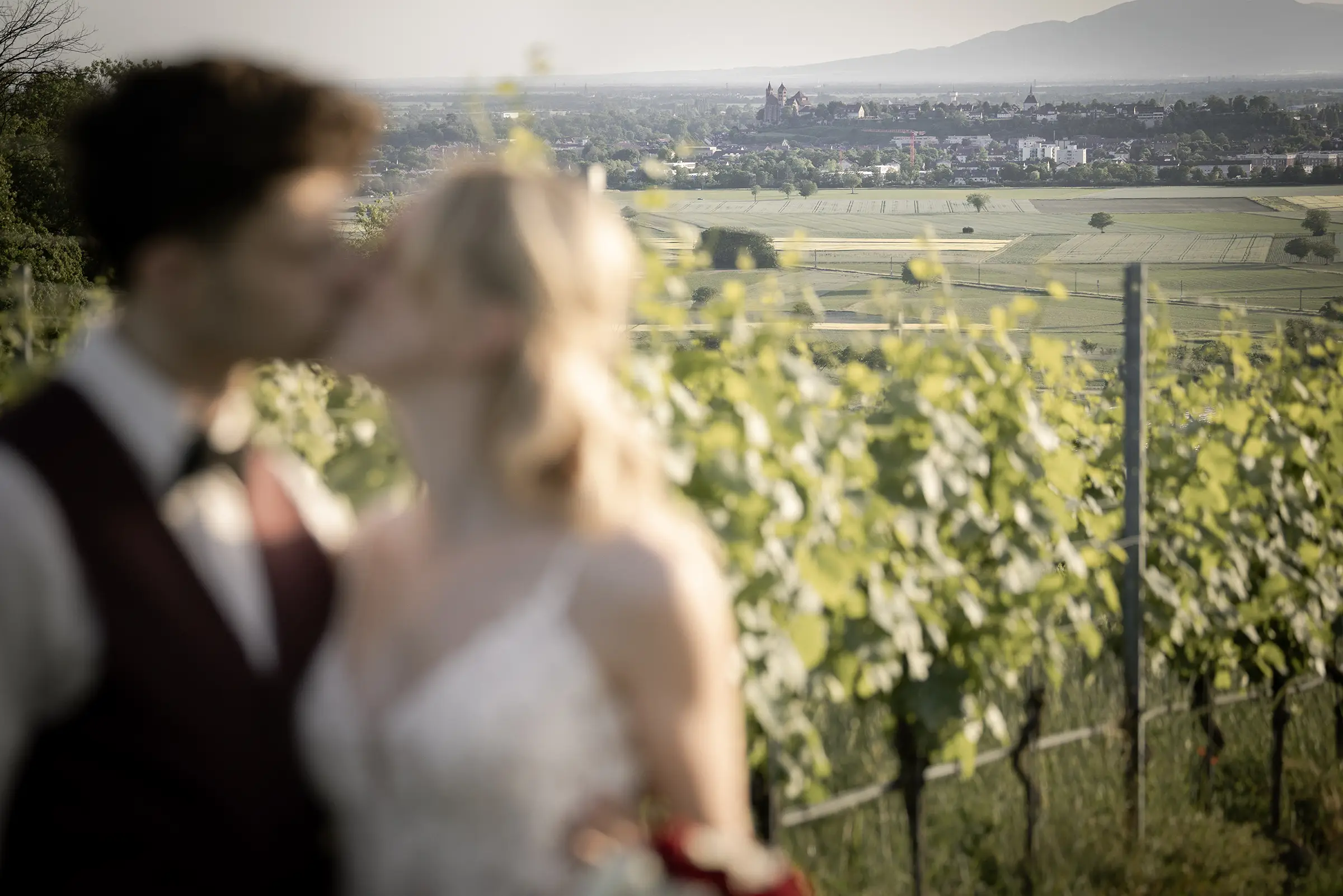 Breisach im Hintergrund während das Hochzeitspaar sich in Bokeh küsst
