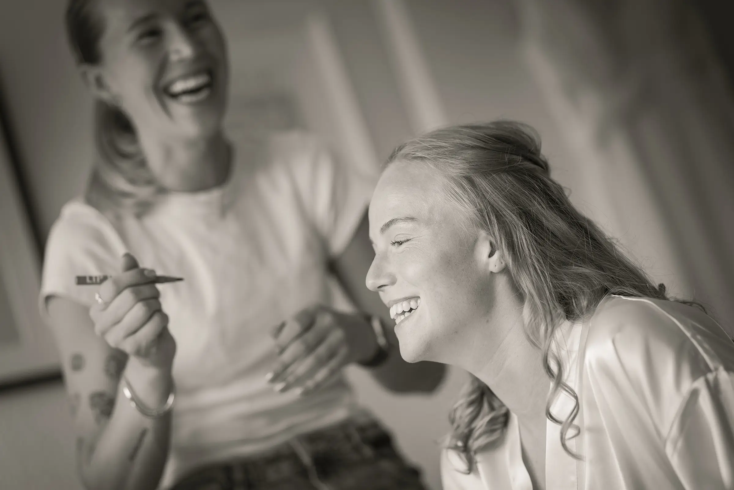 Braut und Freundin lachen beim Getting Ready zuhause in Freiburg