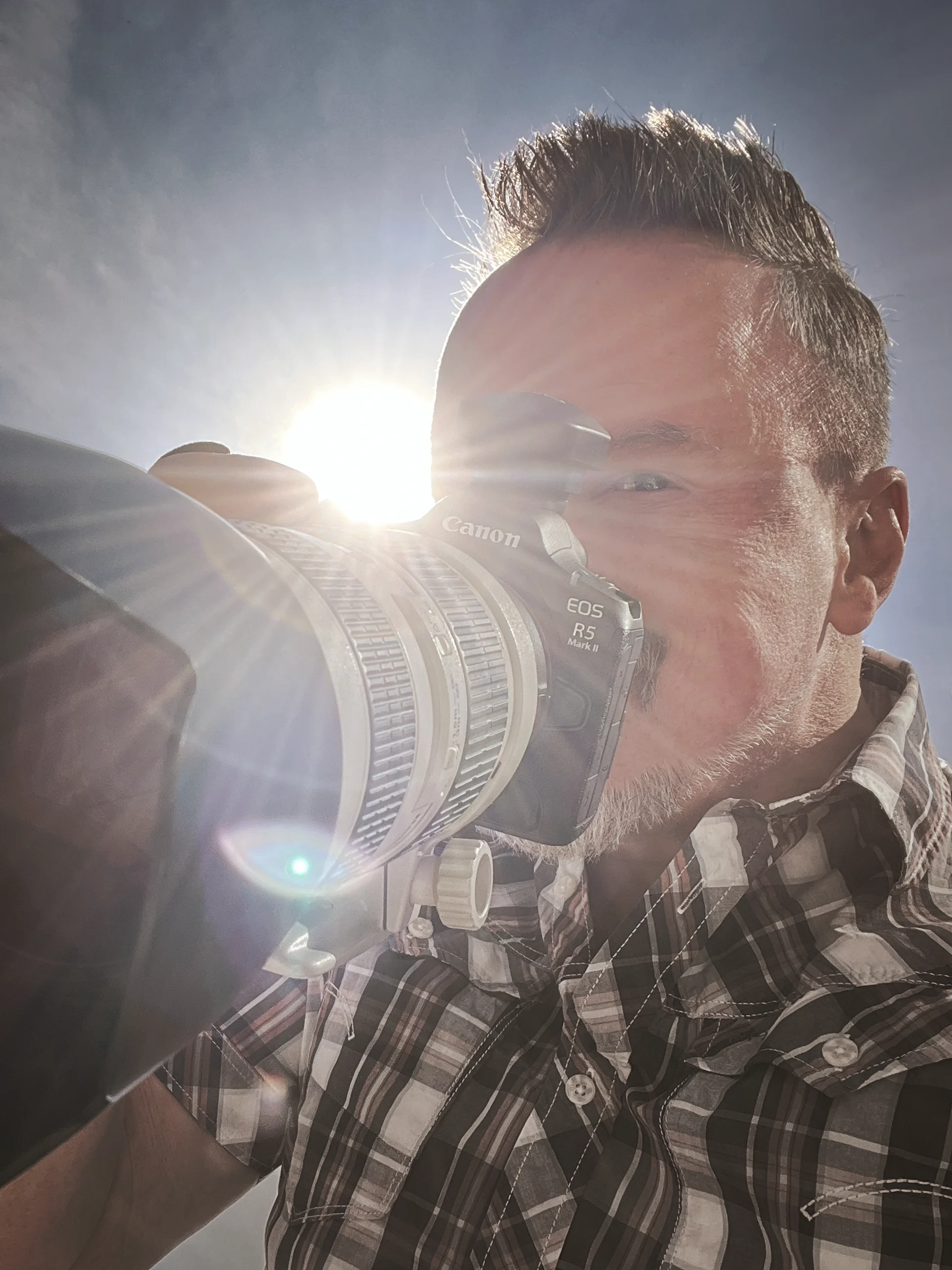 Denis Michel, Hochzeitsfotograf aus Breisach, mit seiner Kamera im Gegenlicht der Sonne